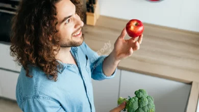 A person juggling various healthy foods while looking at a clock