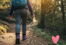 A person hiking in a scenic natural setting with a heart icon overlay