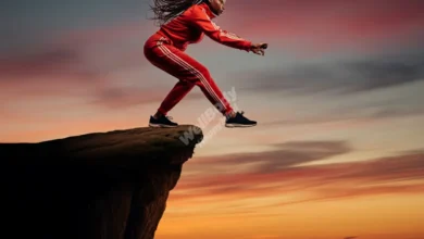 A person standing at the edge of a cliff, looking determined and ready to take a leap