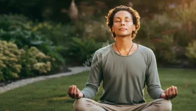 Person practicing mindfulness meditation to develop self-awareness in peaceful garden setting