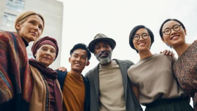 A diverse group of people standing together, supporting each other with caring gestures and warm smiles